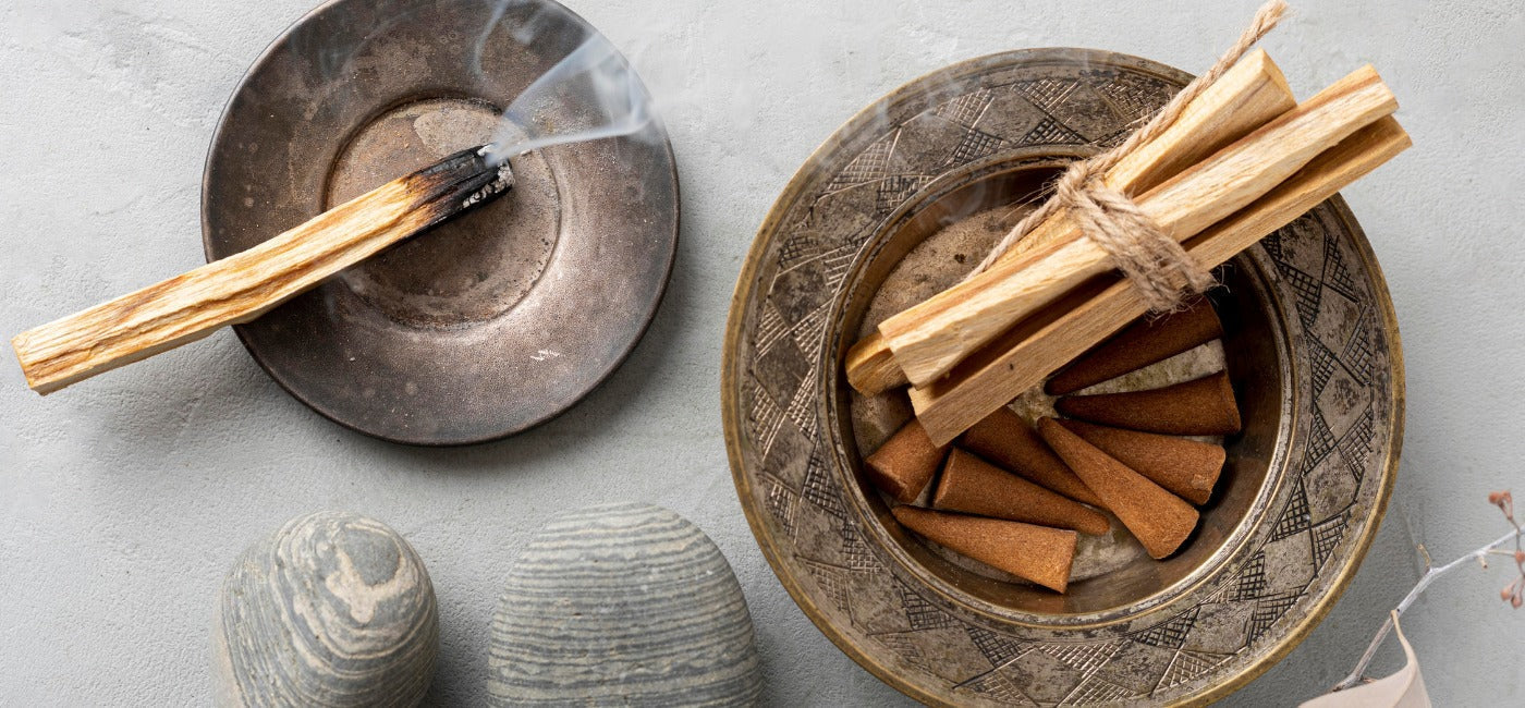 Palo Santo autentico acceso in ciotola decorata per rituali di purificazione e pulizia energetica della casa.