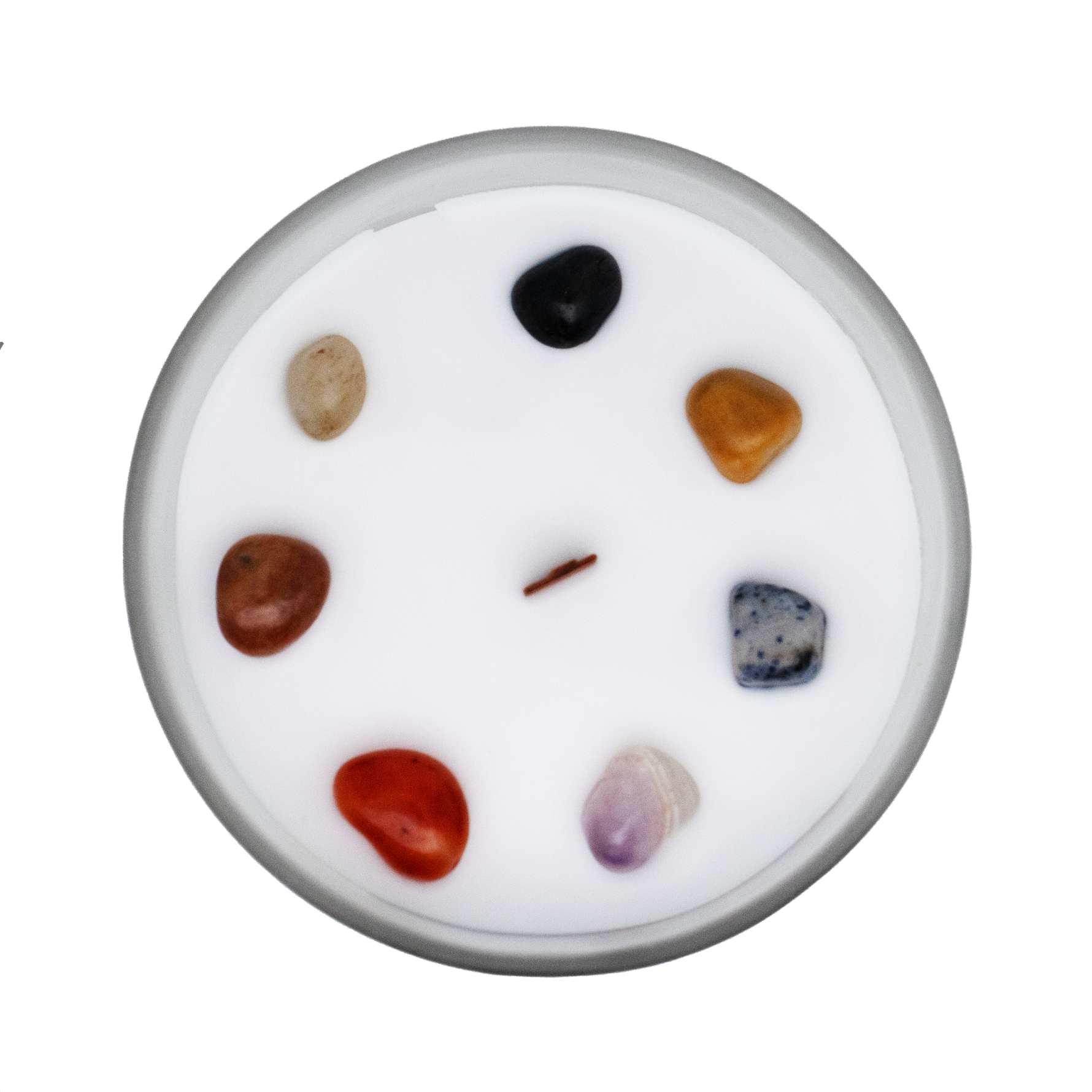 Candela vista dall'alto con pietre dei 7 chakra immerse nella cera