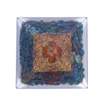 Piramide orgonite con base blu, interno di trucioli metallici oro e sassi blu, con spirale di rame in verticale al centro.