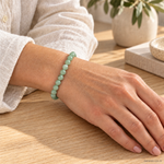 Bracciale in Avventurina Verde - 6mm indossato al polso in un ambiente naturale. Immagine generata con AI.
