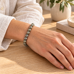Bracciale in Pirite - 8mm indossato al polso in un ambiente naturale. Immagine generata con AI.