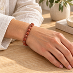 Bracciale in Diaspro Rosso - 8mm indossato al polso in un ambiente naturale. Immagine generata con AI.