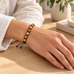 Bracciale artigianale in Palo Santo con Macramè - 8 mm indossato al polso in un ambiente naturale. Immagine generata con AI.
