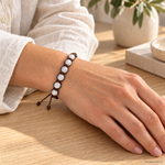 Bracciale artigianale in Pietra di Luna con Macramè - 8 mm indossato al polso in un ambiente naturale. Immagine generata con AI.