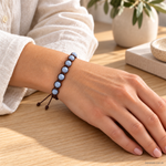 Bracciale artigianale in Angelite con Macramè - 8 mm indossato al polso in un ambiente naturale. Immagine generata con AI.