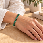 Bracciale in Malachite - 6mm indossato al polso in un ambiente naturale. Immagine generata con AI.