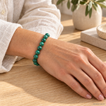 Bracciale in Malachite - 8mm indossato al polso in un ambiente naturale. Immagine generata con AI.