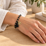 Bracciale Tormalina Nera con Albero della Vita e Nappina - 6mm indossato al polso in un ambiente naturale. Immagine generata con AI.