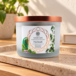 Candela profumata Patchouli e Avventurina Verde da 256 g, con contenitore ed etichetta originali, ambientata su pietra chiara.