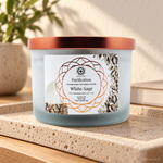 Candela profumata Salvia Bianca e Selenite da 256 g, con contenitore ed etichetta originali, ambientata su pietra chiara.